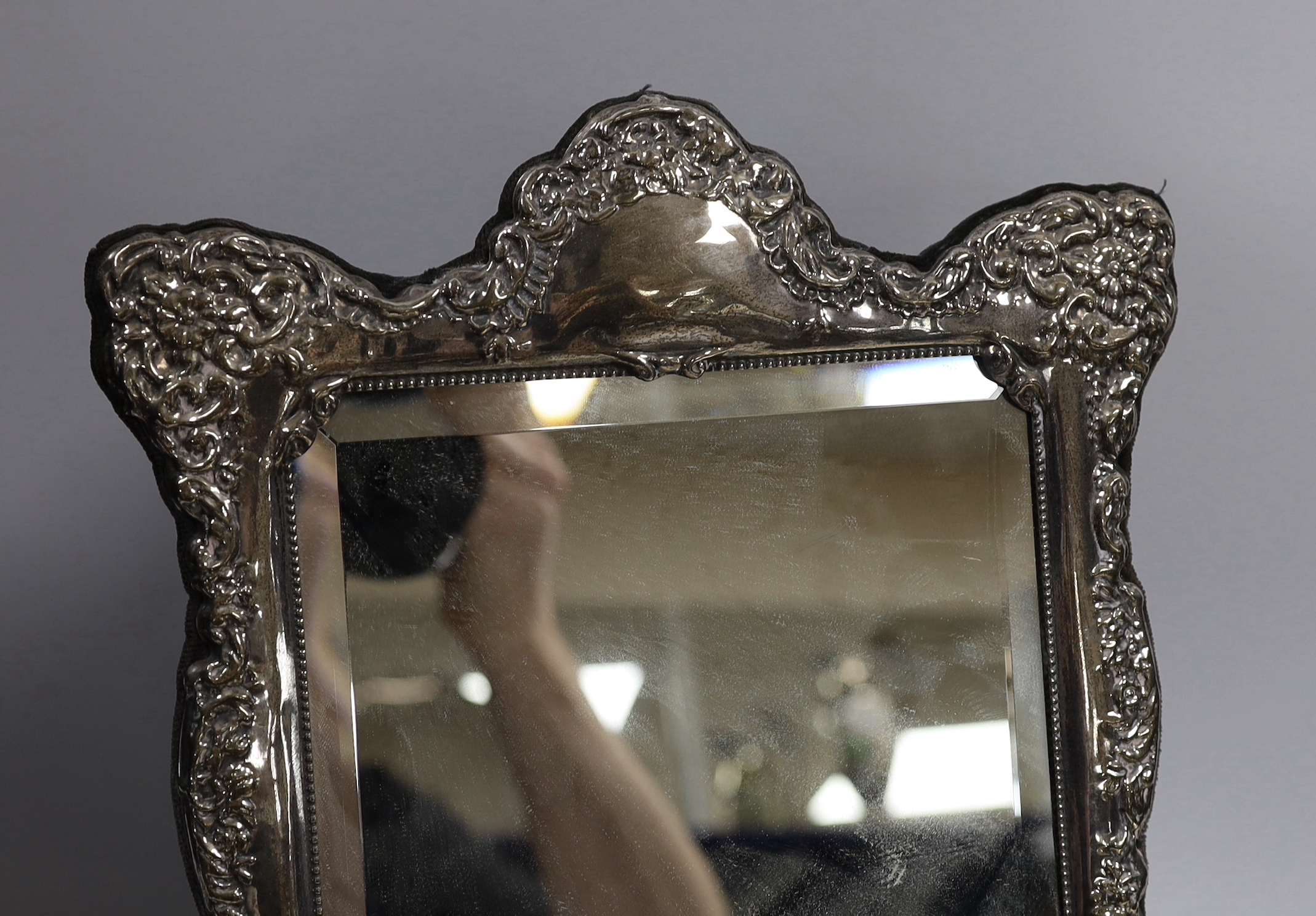 A modern Victorian style embossed silver easel framed mirror, 37cm and a smaller modern silver mounted photograph frame.